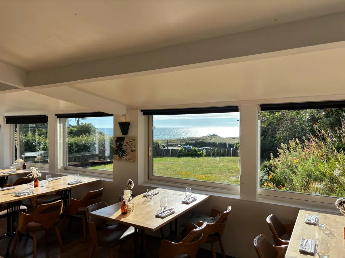 Salle lumineuse du restaurant Le Vert d'O avec vue sur la mer